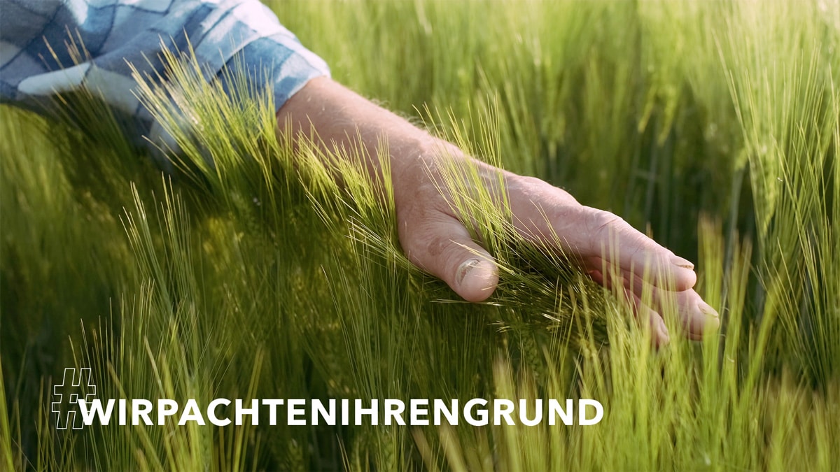 Hand streicht ueber Grund als Symbol fuer Baurecht